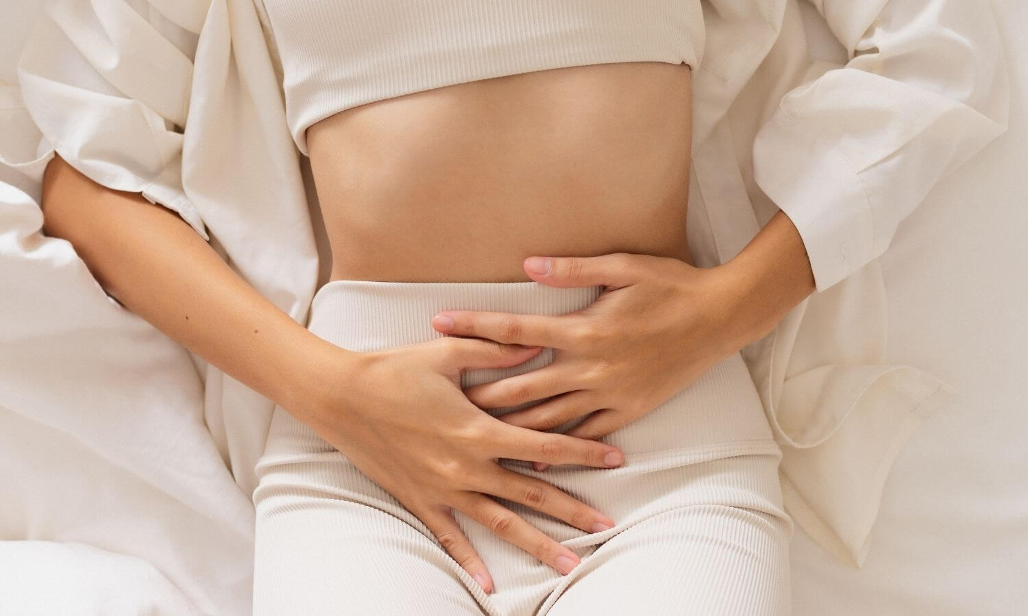 Mujer con dolor abdominal reflejando síntomas de endometriosis, relacionada con problemas de fertilidad.